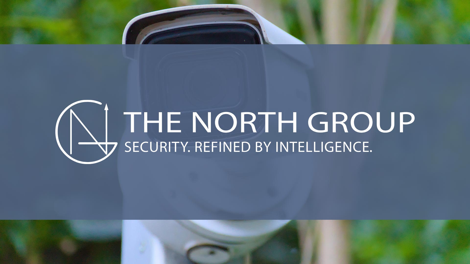 A security camera with "The North Group" logo and the tagline "Security. Refined by Intelligence." displayed over a blurred green background.