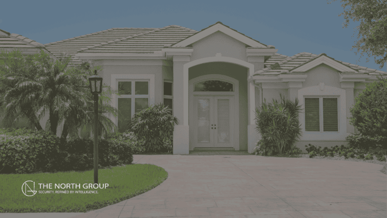 Single-story modern house with manicured landscaping, white exterior walls, and a tile roof; driveway and main entrance are visible. “The North Group” logo is in the lower left corner.